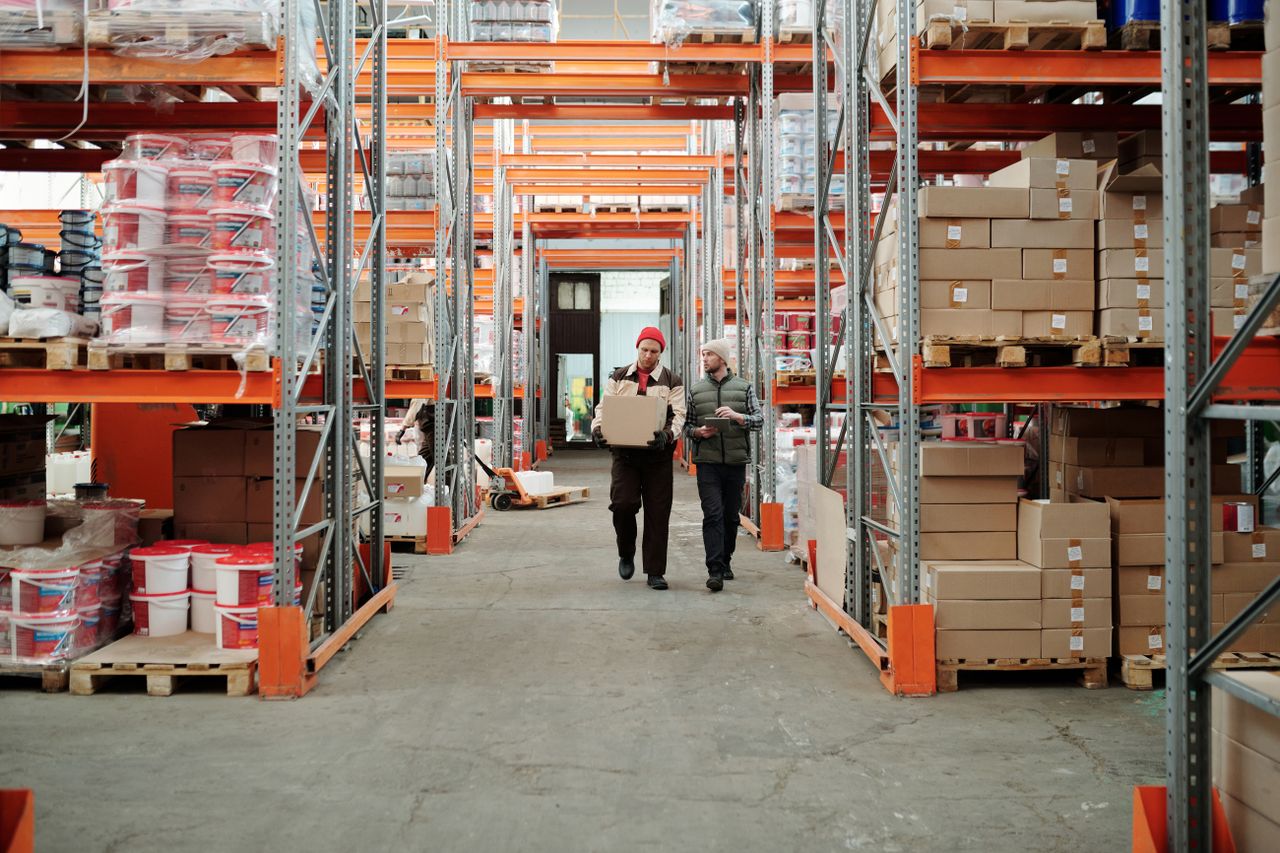 Warehouse fulfillment operations with staff walking distribution aisle
